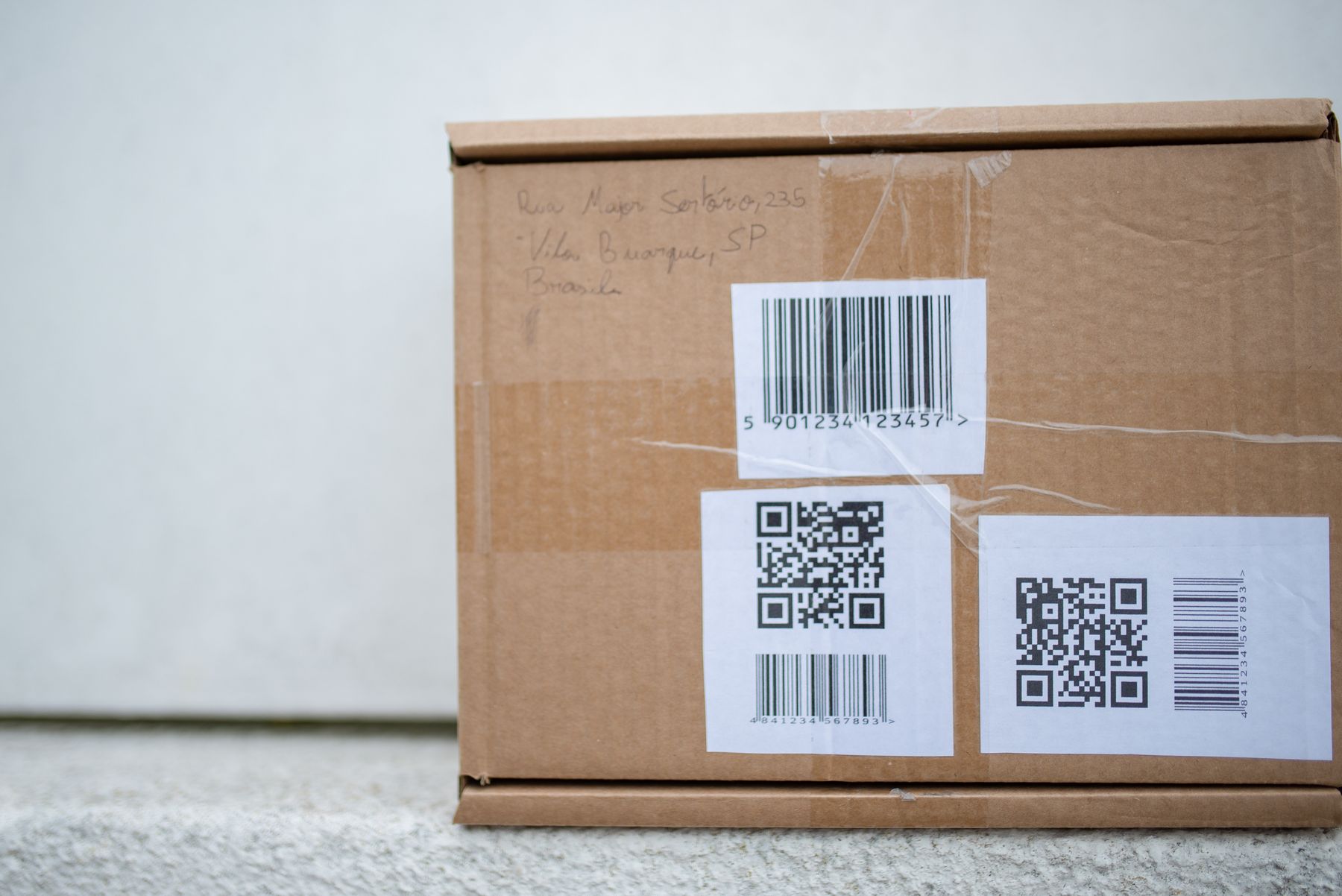 Shipping carton with barcode and QR-code labels